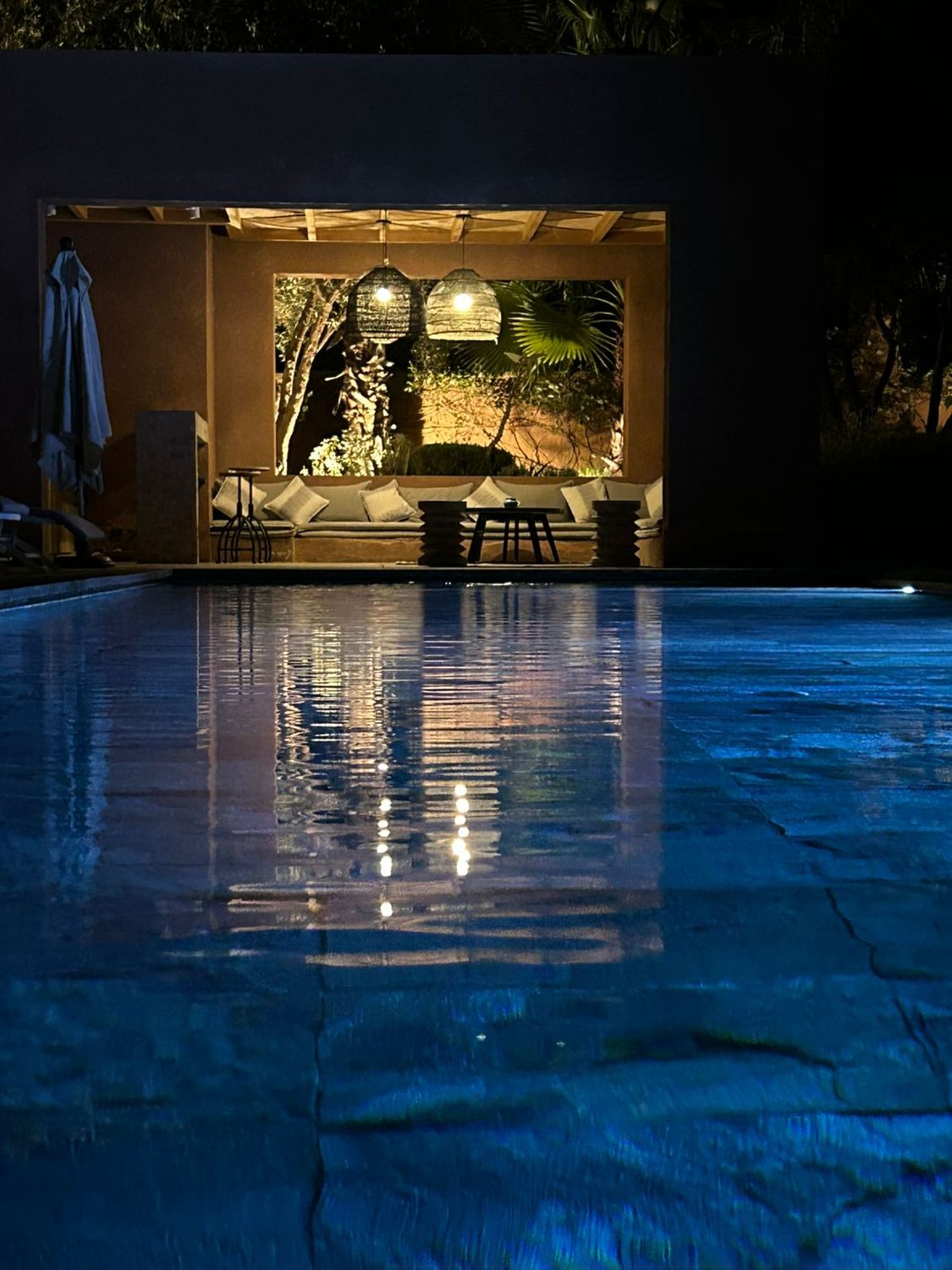 Pool house illuminé reflété dans l'eau